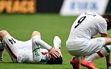 Iran's midfielder Andranik Teymourian (L) and Iran's forward Alireza Jahanbakhsh react after their team lost a Group F football match between Bosnia-Hercegovina and Iran at the Fonte Nova Arena in Salvador during the 2014 FIFA World Cup on June 25, 2014. Bosnia-Hercegovina won 3-1. (photo credit: AFP PHOTO / JAVIER SORIANO)
