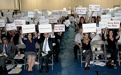Attendees at a rally in Toronto in support of kidnapped Israeli teens, including Israeli Consul DJ Schneeweiss (center left), hold  up #BringBackOurBoys signs in English and Hebrew for photos to be sent to the teens' families. (Courtesy UJA Federation of Greater Toronto)