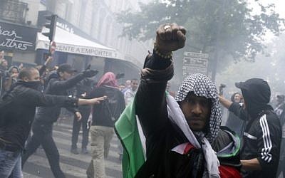 A protester wearing a kaffiyeh and wrapped in a Palestinian flag raises his fist on July 13, 2014 in Paris, during a demonstration against Israel and in support of residents in the Gaza Strip. (photo credit: AFP/KENZO TRIBOUILLARD) A protester wearing a kaffiyeh and wrapped in a Palestinian flag raises his fist on July 13, 2014 in Paris, during a demonstration against Israel and in support of residents in the Gaza Strip. (photo credit: AFP/KENZO TRIBOUILLARD)