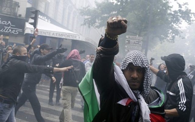 A protester wearing a kaffiyeh and wrapped in a Palestinian flag raises his fist on July 13, 2014 in Paris, during a demonstration against Israel and in support of residents in the Gaza Strip. (photo credit: AFP/KENZO TRIBOUILLARD) A protester wearing a kaffiyeh and wrapped in a Palestinian flag raises his fist on July 13, 2014 in Paris, during a demonstration against Israel and in support of residents in the Gaza Strip. (photo credit: AFP/KENZO TRIBOUILLARD)