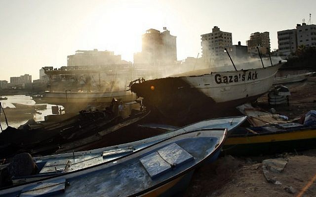 Smoke rises as the peace activist boat 'Gaza's Ark' smolders at sunrise following an Israeli airstrike on Gaza harbor, Friday, July 11, 2014 in Gaza City. (photo credit: Thomas Coex/AFP)