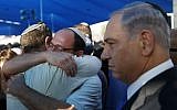 Israeli Prime Minister Benjamin Netanyahu, right, stands next to Avi Fraenkel, left, and Ofir Shaar (2nd left), fathers of two of the three Israeli teenagers killed in the West Bank, during their funeral on July 1, 2014 in the cemetery of Modiin in central Israel. (photo credit: AFP/POOL/BAZ RATNER)