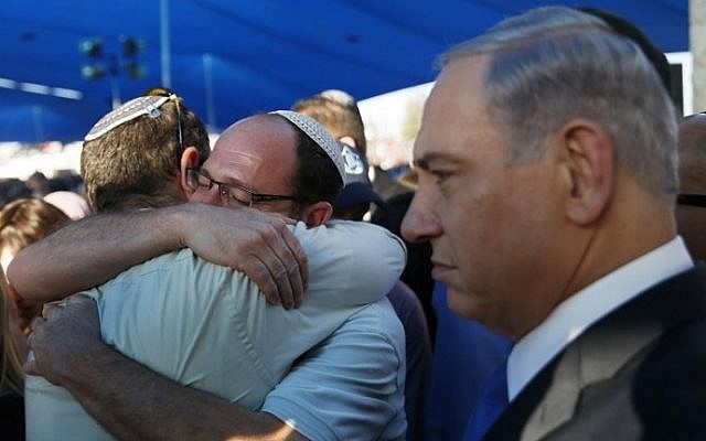 Israeli Prime Minister Benjamin Netanyahu, right, stands next to Avi Fraenkel, left, and Ofir Shaar (2nd left), fathers of two of the three Israeli teenagers killed in the West Bank, during their funeral on July 1, 2014 in the cemetery of Modiin in central Israel. (photo credit: AFP/POOL/BAZ RATNER) Israeli Prime Minister Benjamin Netanyahu, right, stands next to Avi Fraenkel, left, and Ofir Shaar (2nd left), fathers of two of the three Israeli teenagers killed in the West Bank, during their funeral on July 1, 2014 in the cemetery of Modiin in central Israel. (photo credit: AFP/POOL/BAZ RATNER)