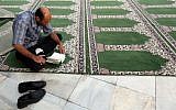 Illustrative photo of a Muslim man reading the Quran  during the holy month of Ramadan (photo credit: Atta Kenare/AFP)