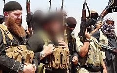 File: An image made available by Jihadist media outlet al-Itisam Media on June 29, 2014, allegedly shows members of the IS (Islamic State), including military leader and Georgian native Abu Omar al-Shishani (Tarkhan Batirashvili) (L) and Sheikh Abu Mohammed al-Adnani (C), whose picture was blurred by the source to protect his identity, speaking at an unknown location between the Iraqi Nineveh province and the Syrian town of Al-Hasakah. (AFP photo/HO/Al-Itisam Media)