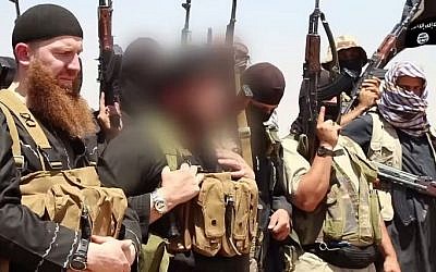 File: An image made available by Jihadist media outlet al-Itisam Media on June 29, 2014, allegedly shows members of the IS (Islamic State), including military leader and Georgian native Abu Omar al-Shishani (Tarkhan Batirashvili) (L) and Sheikh Abu Mohammed al-Adnani (C), whose picture was blurred by the source to protect his identity, speaking at an unknown location between the Iraqi Nineveh province and the Syrian town of Al-Hasakah. (AFP photo/HO/Al-Itisam Media)