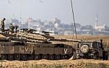 Israeli soldiers sit atop their tanks on the Israeli side of the border with the Gaza Strip, on July 3, 2014 (Jack Guez/AFP)
