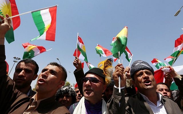 Iraqi Kurdish protesters wave flags of their autonomous Kurdistan region during a demonstration to claim for its independence on July 3, 2014, outside the Kurdistan parliament building in Arbil, in northern Iraq. (photo credit: AFP/Safin Hamed)