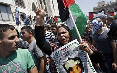 Mourners rally for the funeral of Palestinian youth Mohammed Abu Khdeir, 16, as they carry his body to the mosque during his funerals in Shuafat on July 4, 2014. (photo credit: AFP/THOMAS COEX)