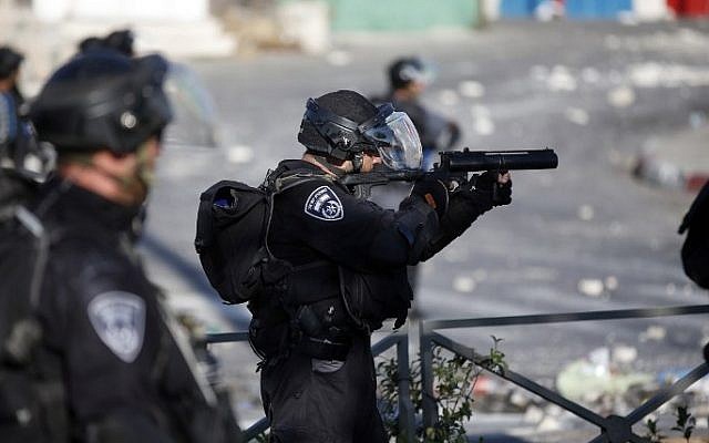 An Israeli policeman prepares to fire sponge projectiles towards protesters during clashes in Shuafat, East Jerusalem on July 4, 2014 (Photo credit: Thomas Coex/AFP) An Israeli policeman prepares to fire sponge projectiles towards protesters during clashes in Shuafat, East Jerusalem on July 4, 2014 (Photo credit: Thomas Coex/AFP)
