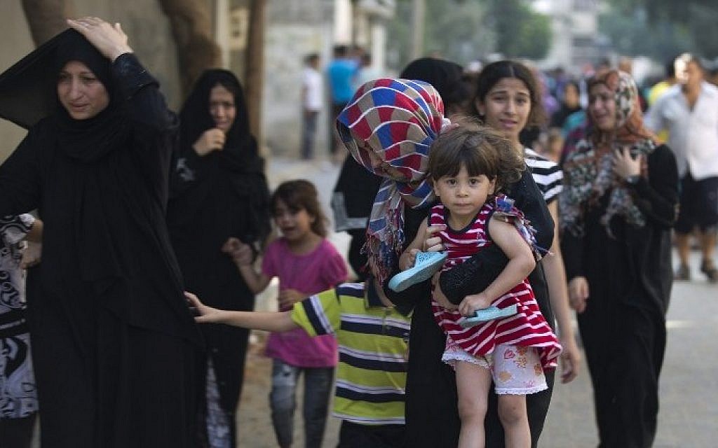 Palestinian families leave their houses following overnight Israeli airstrikes on Gaza City on July 10, 2014. (photo credit: AFP/Mohammed Abed) Palestinian families leave their houses following overnight Israeli airstrikes on Gaza City on July 10, 2014. (photo credit: AFP/Mohammed Abed)
