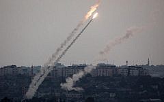 A picture taken from the southern Israel-Gaza border shows a rocket being launched from the Gaza Strip into Israel on Friday, July 11, 2014. (photo credit: Menahem Kahana/AFP)