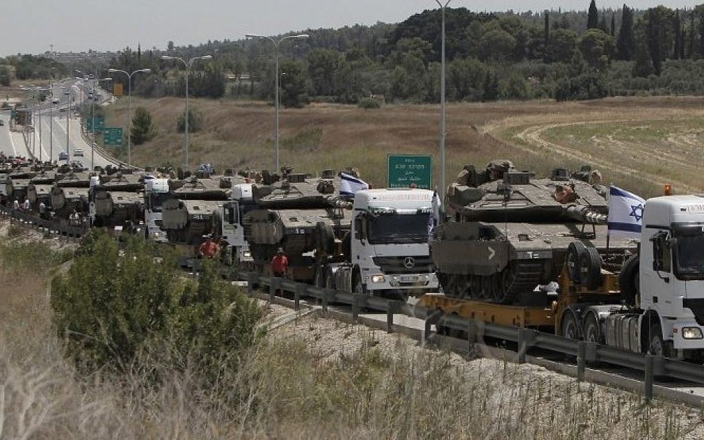 Trucks transport IDF tanks on a road leading to southern Israel, on July 12, 2014, as Israel warns of a possible ground operation in the Gaza Strip (Photo credit: Ahmad Gharabli/AFP)