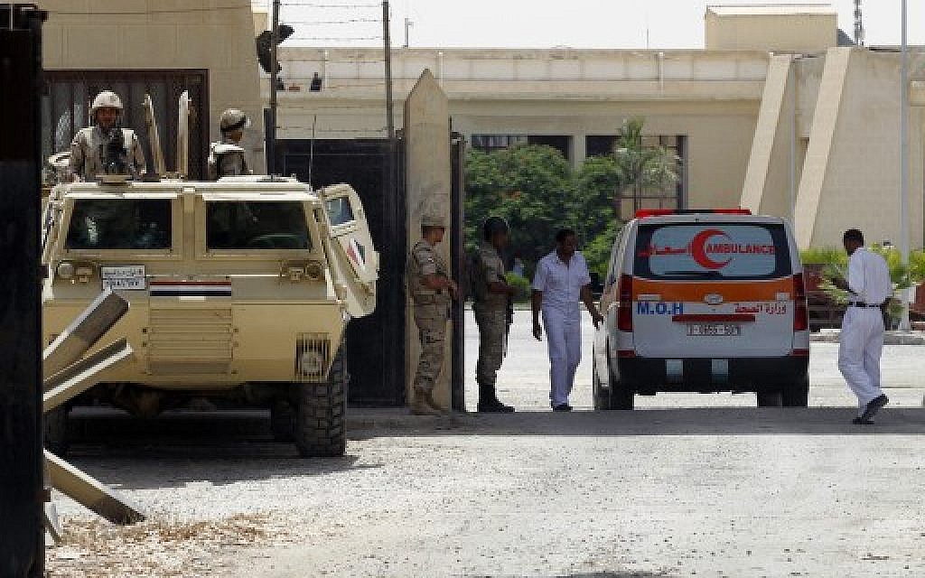 Egyptian security forces stand guard as an ambulance, carrying a Palestinian who was wounded in an Israeli air strike, crosses the Rafah crossing between Egypt and the southern Gaza Strip on July 12, 2014. (photo credit: AFP/SAID KHATIB)