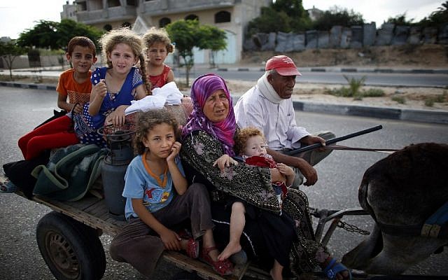 Palestinian families travel to a UN school in Gaza City to seek shelter after evacuating their homes in the northern strip, on Sunday, July 13, 2014 (photo credit: AFP/THOMAS COEX) Palestinian families travel to a UN school in Gaza City to seek shelter after evacuating their homes in the northern strip, on Sunday, July 13, 2014 (photo credit: AFP/THOMAS COEX)