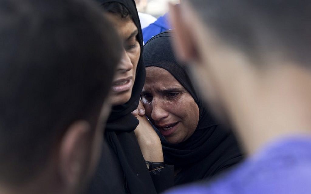 Palestinians grieve over the death of relatives as they wait outside the morgue of the al-Shifa hospital in Gaza city, on July 21, 2014. (photo credit: AFP/MAHMUD HAMS)