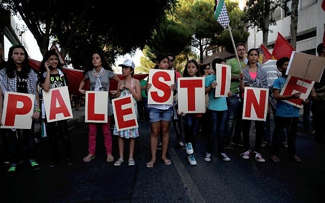 Protesters hold placards painted with letters forming the word 'Palestine' during a demonstration near the Israeli Embassy in the Cypriot capital, Nicosia, against Israel's military offensive on the Gaza Strip, on July 21, 2014. (photo credit: AFP/Yiannis Kourtoglou) Protesters hold placards painted with letters forming the word 'Palestine' during a demonstration near the Israeli Embassy in the Cypriot capital, Nicosia, against Israel's military offensive on the Gaza Strip, on July 21, 2014. (photo credit: AFP/Yiannis Kourtoglou)