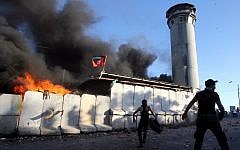 Palestinian protesters throw rocks and fireworks at an Israeli guard tower on July 25, 2014, in the Beit Ummar village, north of the West Bank city of Hebron (Photo credit: Hazem Bader/AFP)
