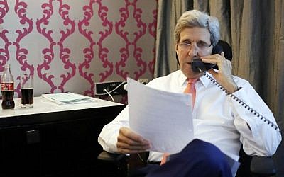 US Secretary of State John Kerry (R) talks to Prime Minister Benjamin Netanyahu (on the phone) on July 25, 2014, from his hotel room in the Egyptian capital, Cairo. (photo credit: AFP/Pool)