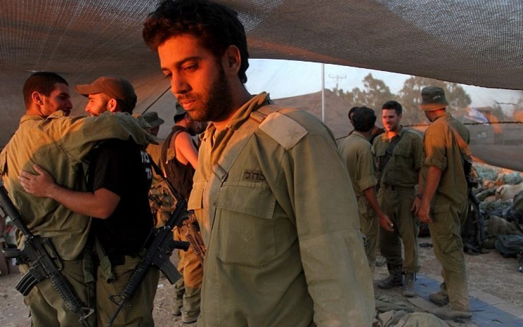Israeli soldiers greet comrades as they rest at an army deployment near the Gaza Strip on July 26, 2014. photo credit: AFP/GIL COHEN-MAGEN)