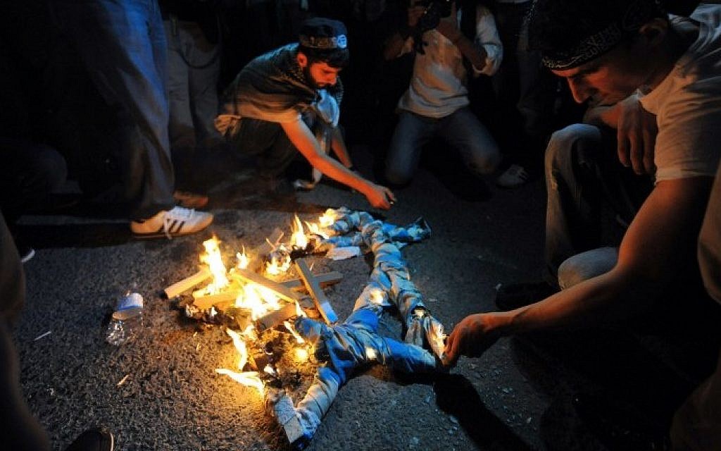 Turkish protestors set fire to a Star of David during a demonstration against the Israeli military operation in Gaza on Friday, July 18, 2014 in front of the Israeli Consulate in Istanbul. (photo credit: Ozan Kose/AFP)
