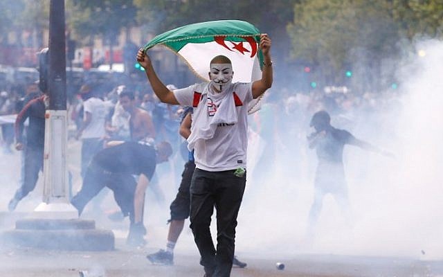 A protester wearing a Guy Fawkes mask and waving an Algerian flag walks through tear gas during clashes with French riot police officers, on the Republique square in Paris, in the aftermath of a banned demonstration against Israel's military operation in Gaza and in support of the Palestinian people, on July 26, 2014 (Photo credit: Kenzo Triboillard/AFP) A protester wearing a Guy Fawkes mask and waving an Algerian flag walks through tear gas during clashes with French riot police officers, on the Republique square in Paris, in the aftermath of a banned demonstration against Israel's military operation in Gaza and in support of the Palestinian people, on July 26, 2014 (Photo credit: Kenzo Triboillard/AFP)