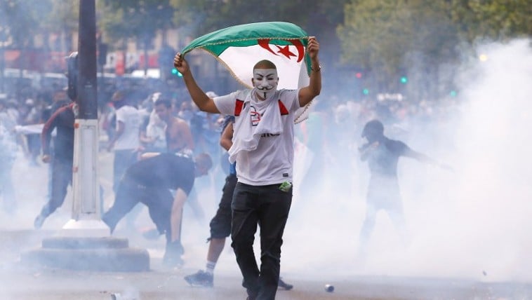 A protester wearing a Guy Fawkes mask and waving an Algerian flag walks through tear gas during clashes with French riot police officers, on the Republique square in Paris, in the aftermath of a banned demonstration against Israel's military operation in Gaza and in support of the Palestinian people, on July 26, 2014 (Photo credit: Kenzo Triboillard/AFP) A protester wearing a Guy Fawkes mask and waving an Algerian flag walks through tear gas during clashes with French riot police officers, on the Republique square in Paris, in the aftermath of a banned demonstration against Israel's military operation in Gaza and in support of the Palestinian people, on July 26, 2014 (Photo credit: Kenzo Triboillard/AFP)