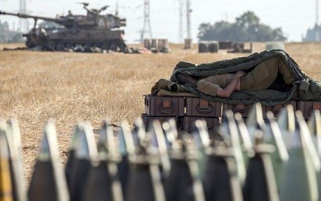 An Israeli soldier sleeps on an ammunition box near an 155mm artillery cannon stationed along the southern Israeli border with the Gaza Strip, Friday, July 11, 2014. (photo credit: Jack Guez/AFP) An Israeli soldier sleeps on an ammunition box near an 155mm artillery cannon stationed along the southern Israeli border with the Gaza Strip, Friday, July 11, 2014. (photo credit: Jack Guez/AFP)