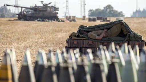 An Israeli soldier sleeps on an ammunition box near an 155mm artillery cannon stationed along the southern Israeli border with the Gaza Strip, Friday, July 11, 2014. (photo credit: Jack Guez/AFP) An Israeli soldier sleeps on an ammunition box near an 155mm artillery cannon stationed along the southern Israeli border with the Gaza Strip, Friday, July 11, 2014. (photo credit: Jack Guez/AFP)