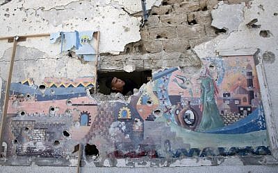 A Palestinian man inspects the damage at a UN school in the Jabalia refugee camp in the northern Gaza Strip, July 30, 2014 (photo credit: AFP/MAHMUD HAMS)