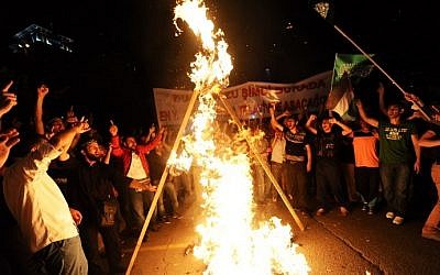 Turkish protesters torch an effigy of Prime Minister Benjamin Netanyahu as they shout slogans during a demonstration against the Israeli military operation in Gaza, Saturday, July 19, 2014 in front of the Israeli Consulate in Istanbul. (photo credit: Ozan Kose/AFP)