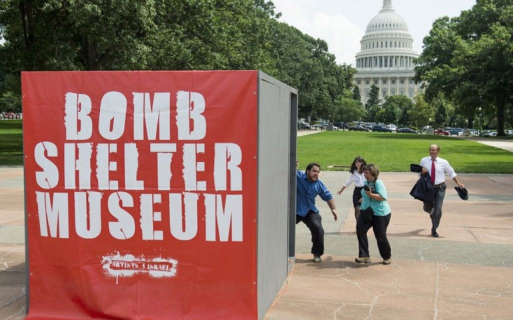 People run towards a mock bomb shelter during a simulated attack by Hamas rockets as part of a multimedia art exhibit called The Bomb Shelter Museum which is modeled after bomb shelters in Israel, near the US Capitol in Washington, on July 22, 2014. (photo credit: AFP/Saul Loeb)