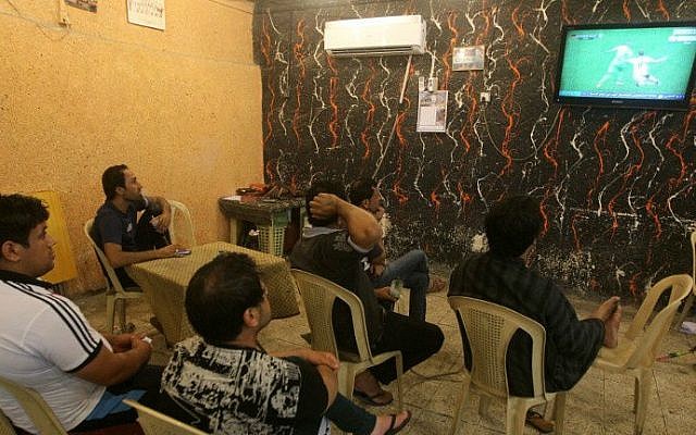 Iraqi Raad Abdulhussein (C) and his friends sit watching on TV the 2014 FIFA World Cup round of 16 football match between Algeria and Germany on July 1, 2014 at the "Facebook" cafe in the Iraqi capital Baghdad. (photo credit: AFP/AHMAD AL-RUBAYE) Iraqi Raad Abdulhussein (C) and his friends sit watching on TV the 2014 FIFA World Cup round of 16 football match between Algeria and Germany on July 1, 2014 at the "Facebook" cafe in the Iraqi capital Baghdad. (photo credit: AFP/AHMAD AL-RUBAYE)