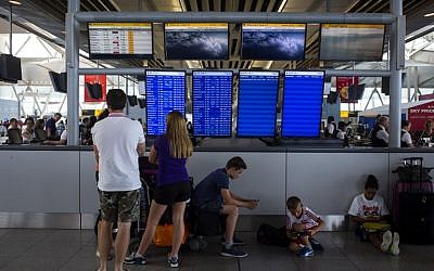 People stand in the Delta Airlines terminal at John F. Kennedy Airport July 22, 2014 in New York City after the Federal Aviation Administration halted all flights from the US to Tel Aviv. ( photo credit: Eric Thayer/Getty Images/AFP)