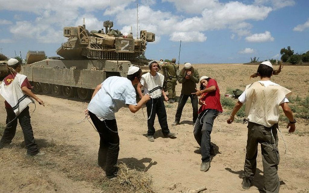 Young Orthodox Jews dance to support the soldiers at an army deployment area near Israel's border with the Gaza Strip, on July 17, 2014 (photo credit: AFP/Menahem Kahana)