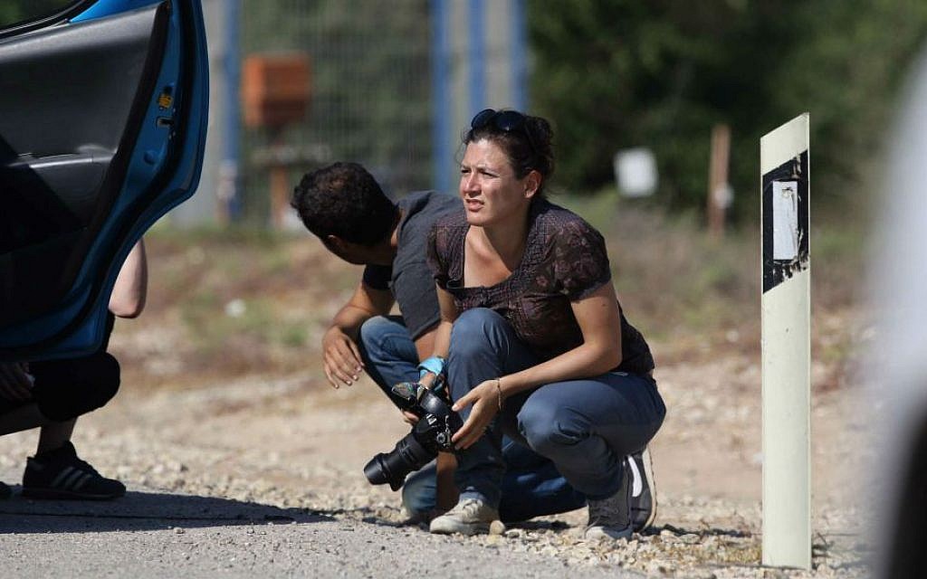 Israelis sit by the side of the road in southern Israel as they take cover when a siren warns of incoming rockets fired from Gaza, into Israel, on July 23, 2014 (photo credit: Nati Shohat/Flash90)