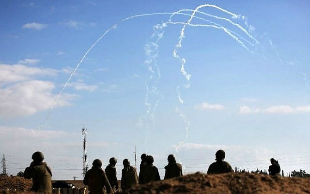 Israeli soldiers watch the smoke trails of 155mm shells fired at targets in the Gaza Strip, at an army deployment area near Israel's border with the Gaza Strip, on July 17, 2014 (photo credit: AFP/Menahem Kahana) 