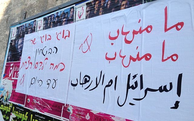 Posters in Arabic and Hebrew read 'Israel is the source of terror' and 'Boogie, how many children have you killed so far' (photo credit: Elhanan Miller/Times of Israel)