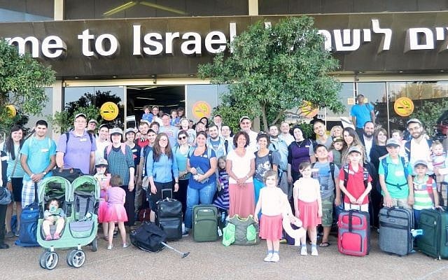 A group photo of the 64 olim who arrived in Israel Tuesday, July 8, 2014, after the commencement of Operation Protective Edge in the Gaza Strip.  (photo credit: Sasson Tiram/Nefesh B'Nefesh)
