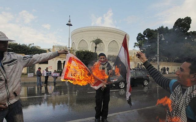 Egyptian protesters burn an Arabic banner reading "Hamas, brotherhood, Qatar and America, are Egyptian enemies," in front of the presidential palace in Cairo, Egypt, Friday, February 1, 2013 (photo credit: AP/Amr Nabil) Egyptian protesters burn an Arabic banner reading "Hamas, brotherhood, Qatar and America, are Egyptian enemies," in front of the presidential palace in Cairo, Egypt, Friday, February 1, 2013 (photo credit: AP/Amr Nabil)