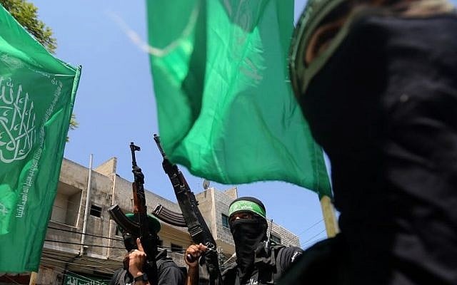 Masked Palestinian members of the Ezz Al-Din Al Qassam brigade, the military wing of Hamas, parade during the funeral of Ahmed Ayad, 22, in the Shajaiyeh neighborhood of Gaza City on Saturday, June 21, 2014 photo credit: AP/Hatem Moussa)
