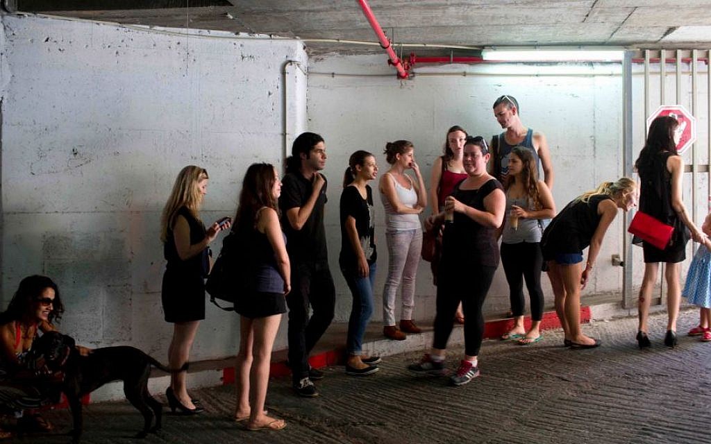 Israelis take cover in an underground parking garage as siren sounds during rocket attack fired by Palestinian militants from Gaza in Tel Aviv, Israel, Thursday, July 10, 2014. (photo credit: AP/Oded Balilty) Israelis take cover in an underground parking garage as siren sounds during rocket attack fired by Palestinian militants from Gaza in Tel Aviv, Israel, Thursday, July 10, 2014. (photo credit: AP/Oded Balilty)