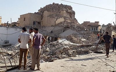 People inspect the destroyed old Mosque of The Prophet Jirjis in central Mosul, Iraq, Sunday, July 27, 2014. The revered Muslim shrine was destroyed by extremists who overran the city in June and imposed their harsh interpretation of Islamic law (photo credit: AP) People inspect the destroyed old Mosque of The Prophet Jirjis in central Mosul, Iraq, Sunday, July 27, 2014. The revered Muslim shrine was destroyed by extremists who overran the city in June and imposed their harsh interpretation of Islamic law (photo credit: AP)