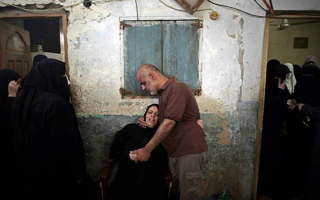 Palestinian relatives of eight members of the Al Haj family, who were killed in a strike early morning, grieve in the family house during their funeral in Khan Younis refugee camp, southern Gaza Strip on Thursday, July 10, 2014. (AP Photo/Khalil Hamra)
