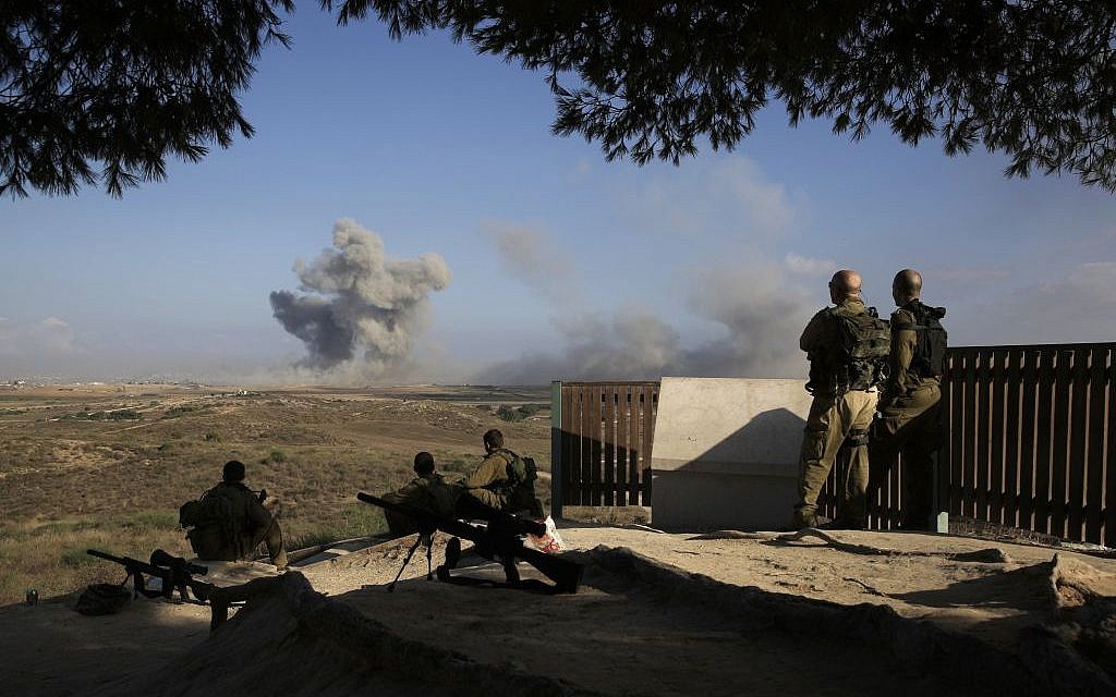 Israeli soldiers observe bombings of Gaza before a 12-hour cease-fire, seen from the border of Israel and the Gaza Strip on Saturday, July 26, 2014. (photo credit: AP/Tsafrir Abayov)