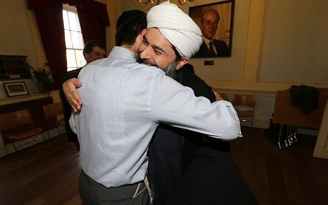 Rabbi Natan Levy and Muslim leader Sheikh Ibrahim Mogra embrace at a Holocaust exhibition  at  the Board of Deputies of British Jews in 2013. (courtesy: Natan Levy)