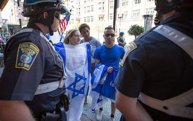 Boston police officers protect student Israel supporters (from left) Samantha Mandeles, Chloe Valdary, and Raphael Fils during an anti-Israel protest on Friday. Minutes after this photo was taken, up to 100 pro-Palestinian supporters "swarmed" the small group of Israel supporters (photo credit: Elan Kawesch/The Times of Israel)