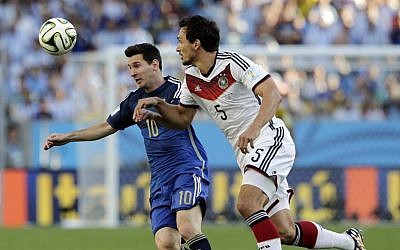 Argentina's Lionel Messi, left, battles for the ball with Germany's Mats Hummels during the World Cup final soccer match between Germany and Argentina at the Maracana Stadium in Rio de Janeiro, Brazil, Sunday, July 13, 2014. (photo credit: AP Photo/Matthias Schrader)