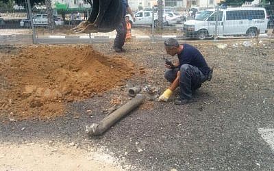 Sappers examine a rocket fired at the coastal city of Ashkelon, Sunday, July 13, 2014 (photo credit: Israel Police/Twitter)