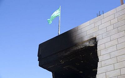A Hamas flag flutters above the Abu Aysha home in Hebron a day after the IDF stormed and detonated it. Security forces demolished the home overnight Sunday, August 18, 2014. (photo credit: courtesy/Queralt Gómez Cuberes)